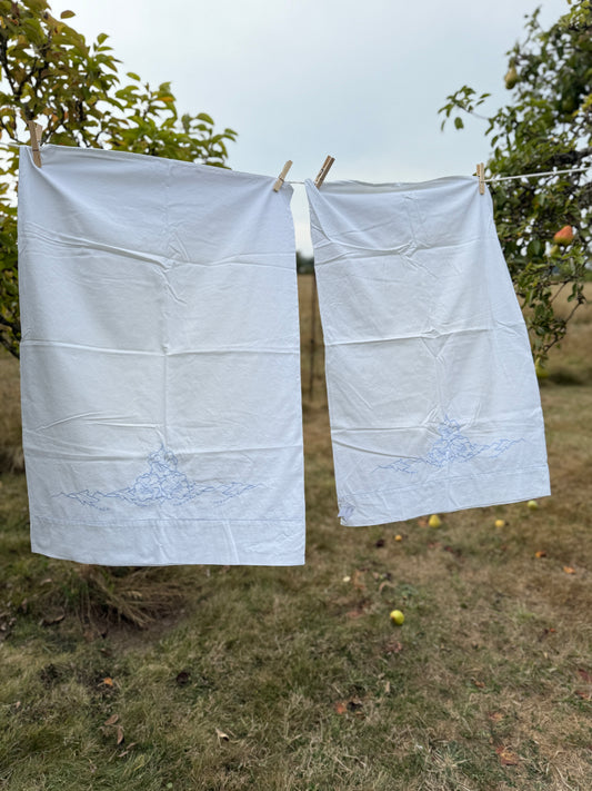 AA. Pair of white pillowcases with blue cut out embroidery